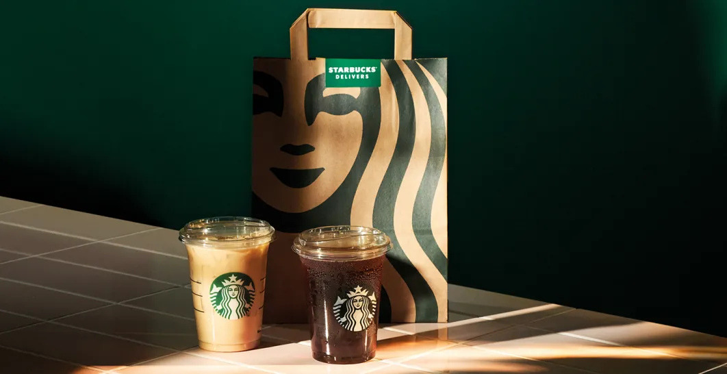 Starbucks Paper Bag with 2 Beverages placed infront, ready to get picked up by a delivers driver to be delivered to a customer